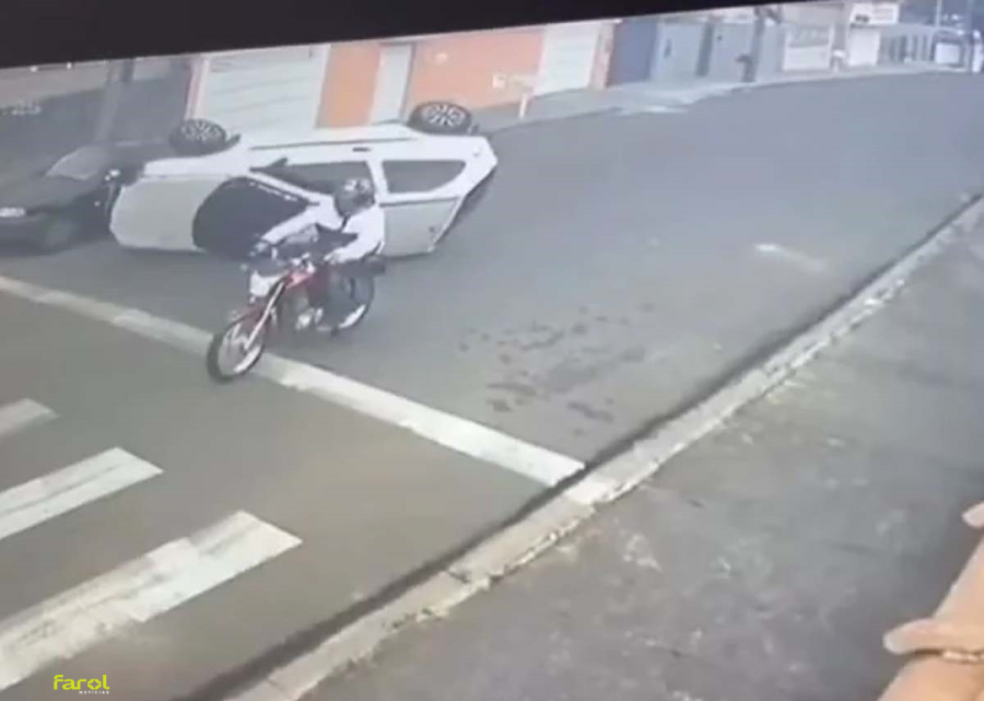 Carro capota após bater em veículo estacionado e quase atinge motociclista 